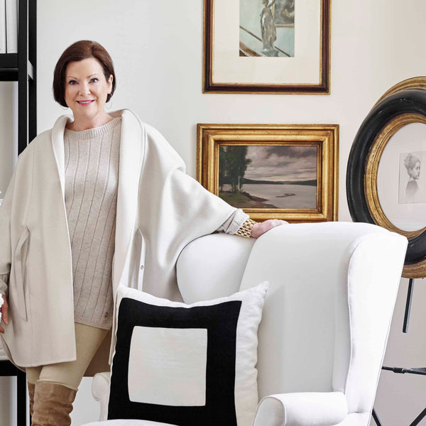 Image of Beth Webb standing by a white chair