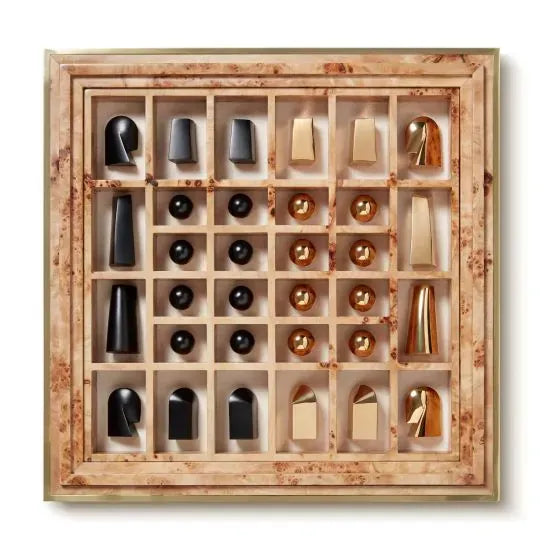 An AERIN Shagreen Chess Set with contemporary black and gold pieces is displayed inside a sumptuous wooden grid tray, each piece occupying its own compartment, making it a truly luxurious chess set by Aerin.