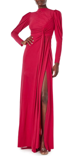 A person wearing a Monique Lhuillier Jewel Neck Long Sleeve Draped Gown by Monique Lhuillier, standing with one hand on their hip.