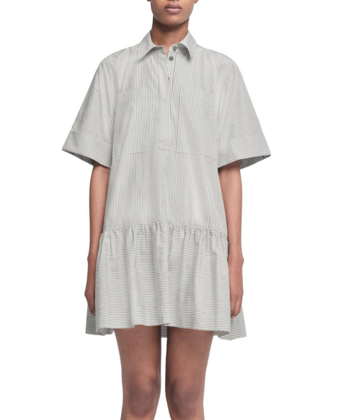 A person wearing the Simkhai Cris Dress, a short-sleeved, button-up striped dress made of 100% cotton, featuring a drop waist and pleated skirt by Simkhai.