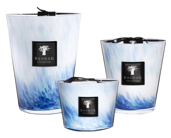 Three Baobab Eden Seaside candles from the Baobab Collection, each featuring a unique blue and white marbled pattern with black labels, fill the air with the calming scent of vetiver.