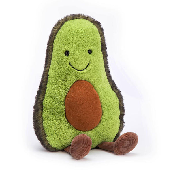 An adorable plush toy in the shape of an avocado, known as the Jellycat Amuseable Avocado, Medium, with a green body, brown pit, and a smiling face, sitting with its legs extended. This soft veggie toy brings joy and comfort to all who hold it.