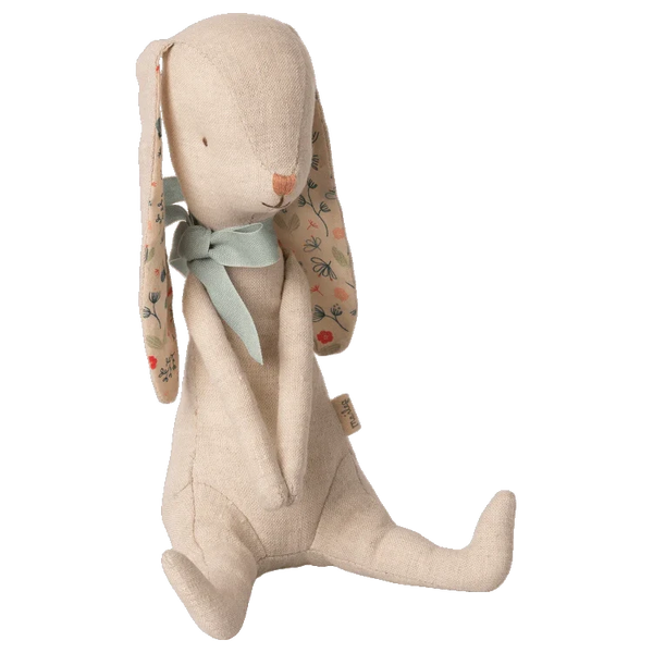 The Maileg Bunny Albin, by Maileg, is crafted from soft linen quality and features floral-patterned ears, a green fabric neck bow, and simple stitched facial features. This charming rabbit doll sits upright and has magnets in its hands for added versatility.