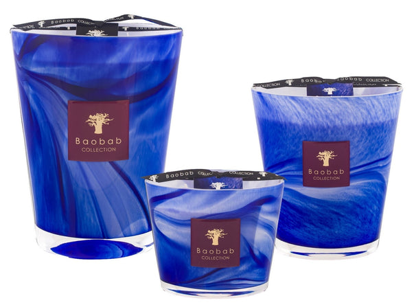 Three Baobab Collection Atlas Majorelle candles in blue, available in various sizes, feature decorative swirled patterns and branded labels, infused with the enchanting essence of orange blossom.