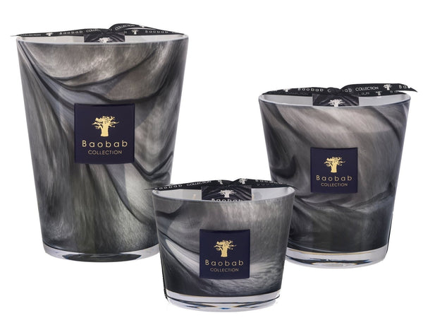 The Baobab Atlas Toubkal Collection includes three candles in different sizes, each showcasing gray and black marbled glass with branded labels, all infused with the delicate aroma of Atlas cedar.