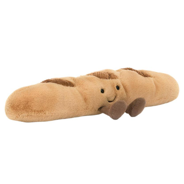 Introducing the Jellycat Amuseables Baguette plush toy by Jellycat, designed as a charming baguette complete with a cheerful face and little brown feet. This golden loaf is made for comfort and delight, offering a huggable experience that brings joy to anyone who cuddles it.