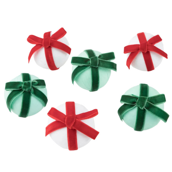 The MERI Big Bow Surprise Balls (6) by Meri Meri, featuring red and green velvet bows, are arranged in a scattered pattern on a plain background, making them ideal as party favors.