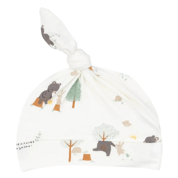 The Angel Dear Bear and Bunny Adventures Knotted Hat is a white bamboo spandex baby hat featuring an adjustable knot, adorned with illustrations of bears, trees, and woodland creatures in soft colors.