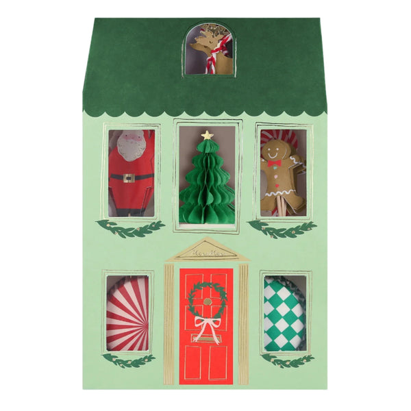 A Meri Meri Festive House Cupcake Kit, designed as a house-shaped advent calendar in green and red, features paper cutouts of a reindeer, Santa suit, Christmas tree, gingerbread person, and candy. Peek through the windows to uncover festive delights like charmingly designed Christmas cupcakes.