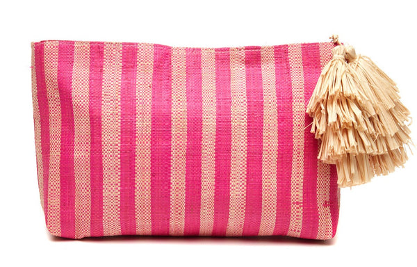 The Mar Y Sol Esme Bag by Mar Y Sol is a chic warm weather accessory, featuring a rectangular pink and natural striped woven design with a fringed tassel attached to one side, perfect for adding a touch of summer flair.