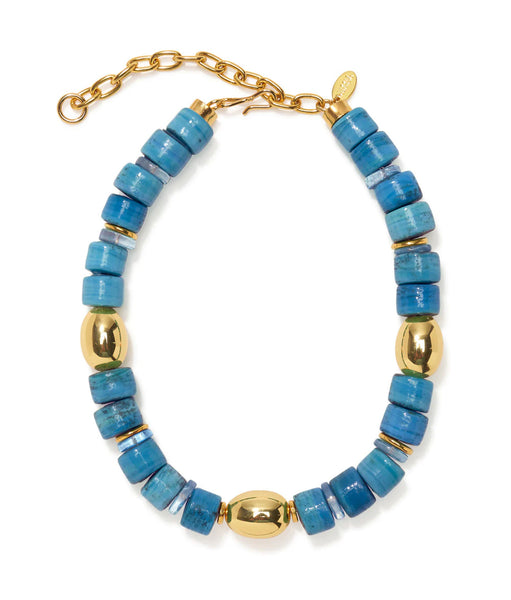 The Lizzie Fortunato Varuna Collar is a beaded necklace showcasing alternating blue and gold beads, complete with an adjustable, gold-plated chain clasp and subtly accented with glass and quartz elements.