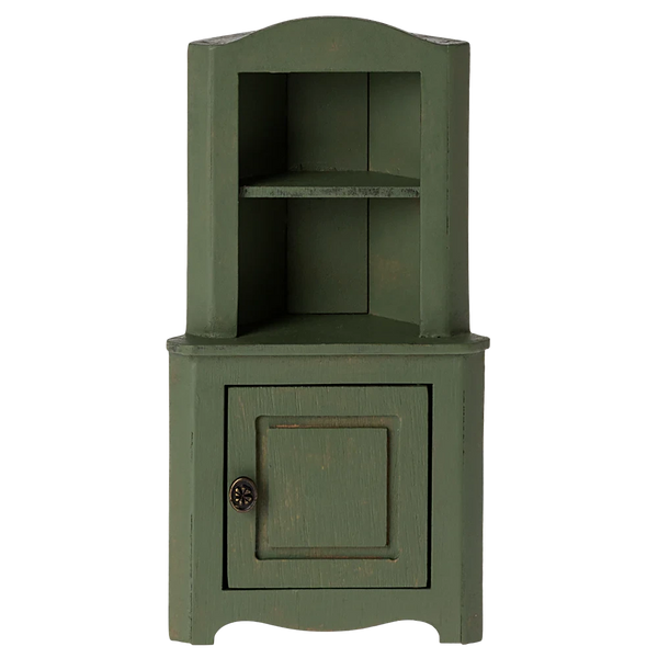 The Maileg Corner Cabinet, Mouse - Dark Green by Maileg is a green wooden corner cabinet with a vintage finish that features one open shelf on top and a closed compartment with a single door on the bottom, perfect for adding charm to a farmhouse-style mouse hole space.