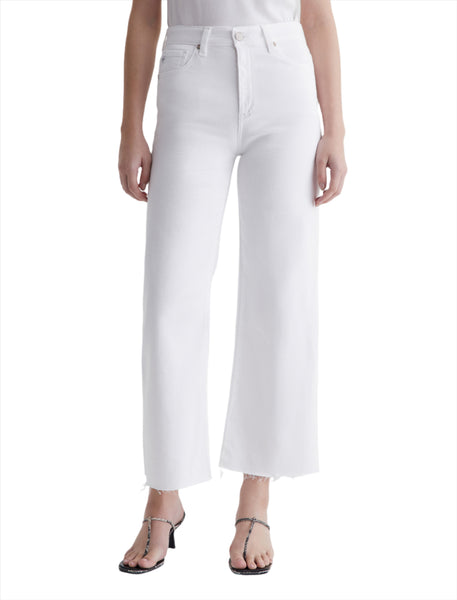 Person wearing high-waisted, AG Saige Wide Leg Crop jeans from AG Jeans with raw hems, paired with a white top and black strappy sandals.