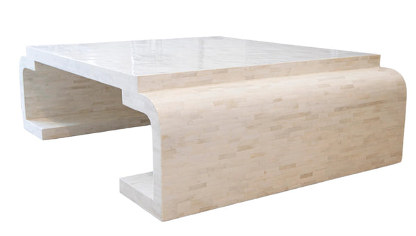 The Deco Coffee Table by Bojay is a cream-colored, modern rectangular piece featuring bone inlay details, a smooth surface, and rounded edges, elegantly placed on a light carpet in a living room setting.