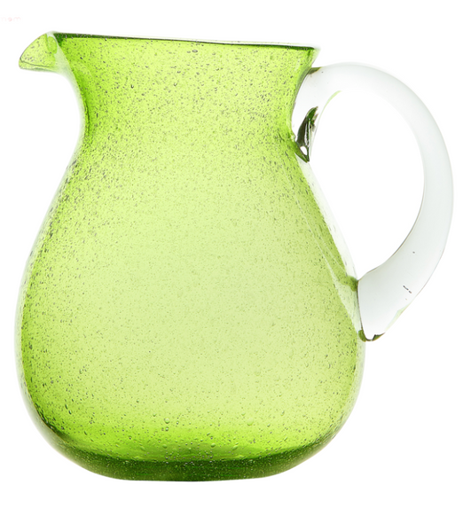 A translucent green Memento Acrylic Pitcher Collection, showcasing unique colors, with condensation droplets on its surface, isolated on a white background.