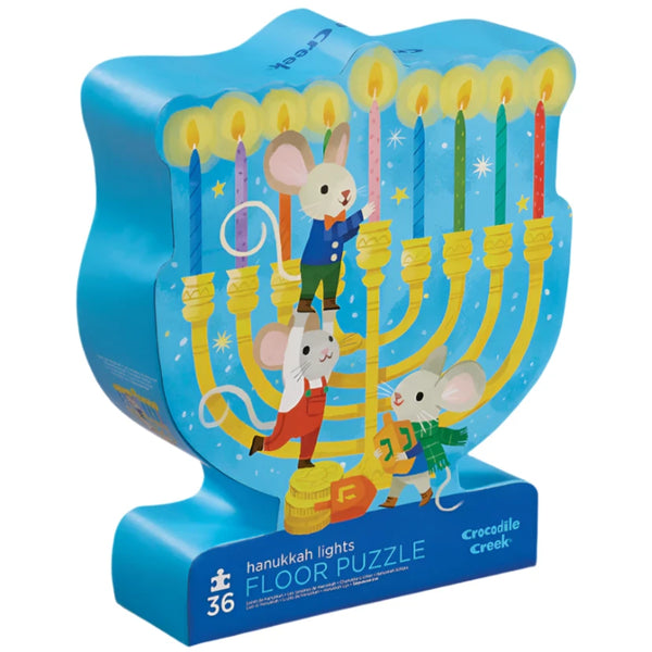 The Crocodile Creek Hanukkah Lights 36 Piece Puzzle, by Crocodile Creek, is a vibrant menorah-shaped puzzle featuring mice lighting candles. This colorful illustration puzzle uses soy-based ink for an eco-friendly touch.