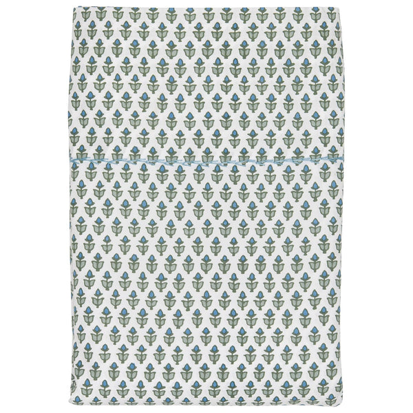 This folded white blanket from the John Robshaw Cala Sage Bedding Collection by John Robshaw is crafted from organic cotton percale and showcases a stunning pattern of green and blue floral designs reminiscent of a blockprint bouquet.