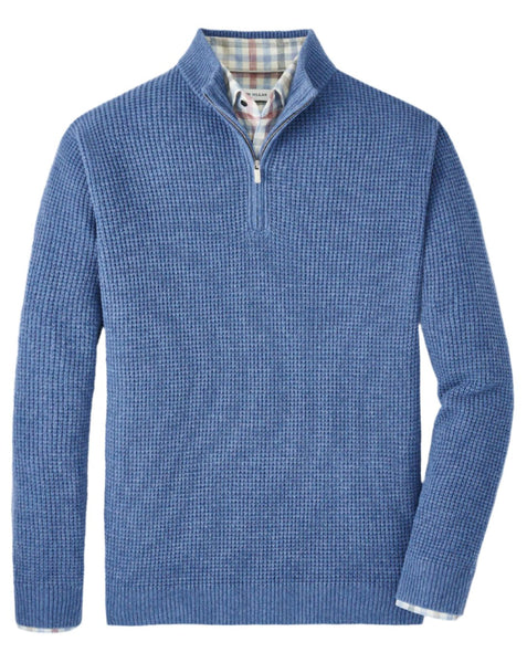 A Peter Millar Crescent Waffle Quarter Zip sweater for men in blue, featuring a textured waffle knit pattern and a stylish quarter-zip design, layered over a plaid collared shirt.