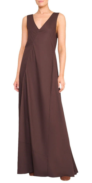 A person wearing a sleeveless dark brown V-neck cotton stretch Staud Roma Dress stands against a white background. This classic day to night dress from Staud is a true closet staple, blending comfort and style effortlessly.