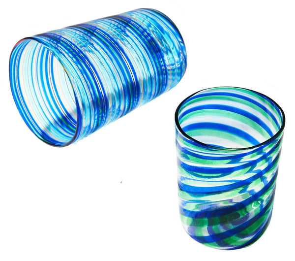 Two tumblers from the Aquazzura Murano Rainbow Swirl Tumbler Collection by Aquazzura Casa: one standing upright, the other lying on its side, showcasing the artistry of handblown Murano glass in shades of blue and green.