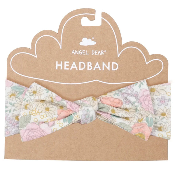 The Angel Dear Peonies and Roses Headband is a floral-patterned accessory crafted from soft bamboo viscose with a hint of spandex. It is displayed on cardboard backing adorned with delightful Angel Dear illustrations and the text "Angel Dear Headband.