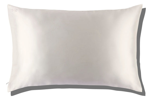 A rectangular, white pillow with a silk texture is showcased against a white background, featuring the Slip Silk Queen Pillowcase by Slip to help reduce sleep wrinkles.