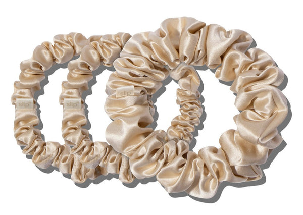 Three beige silky scrunchies, made from slipsilk™, are arranged in a row against a plain white background, perfect for hair damage prevention. These scrunchies are part of the Slip Silk Midi/Large Scrunchie Set by Slip.