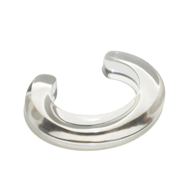 A clear cuff bracelet on a white background, featuring a lucite material.