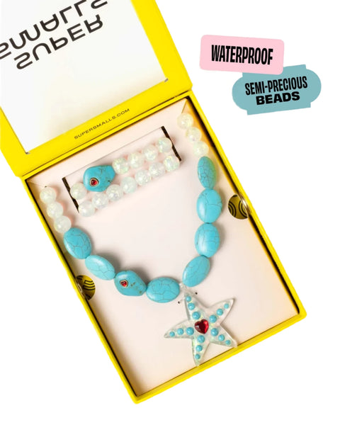 The Supersmalls Super Star Mega Set by Super Smalls includes a stretchy turquoise bead bracelet and a star pendant necklace, all beautifully packaged in a yellow box. The text on the box reads "WATERPROOF" and "SEMI-PRECIOUS BEADS.