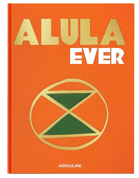 Orange book titled "AlUla Ever" with gold and green geometric designs on the cover, highlighting AlUla, a UNESCO World Heritage Site in Saudi Arabia. The publisher's name "Assouline" appears at the bottom.