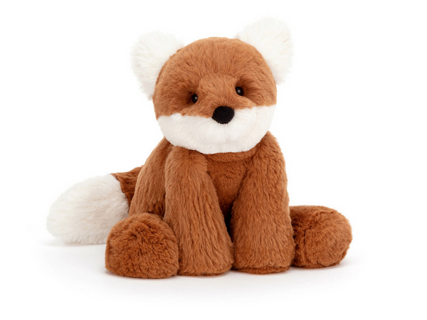 A Jellycat Smudge Fox with brown and white fur, featuring fluffy cream ears, is sitting upright on a white background.