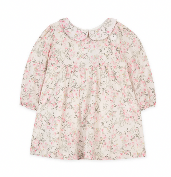 The Tartine et Chocolat Peter Pan Collar Printed Floral Dress by Tartine et Chocolat is a long-sleeve dress for a baby girl featuring a white-collared neckline. The fabric is adorned with light pink flowers on a beige background, creating a delicate pale pink floral motif.