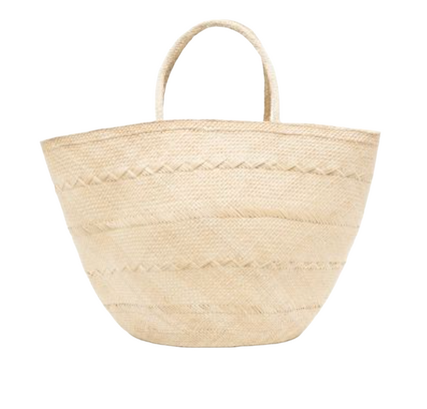 A beach-ready beige woven straw tote bag with two curved handles and a zigzag pattern on the body, hand-woven from Iraca palm, is the Ulla Johnson Marta Basket Tote, Large by Ulla Johnson.