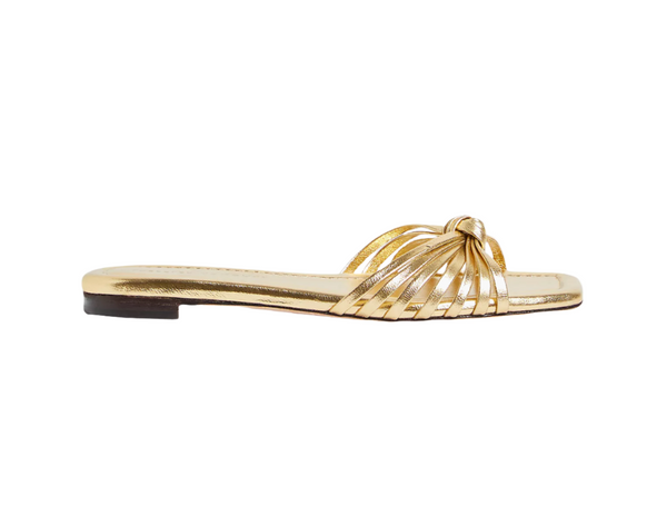 The Loeffler Randall Izzie Sandal features multiple thin straps of metallic leather that loop together in a knotted detail at the front, complete with a sleek black flat sole.