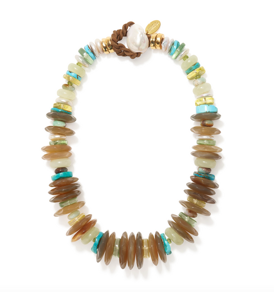 This image showcases the Lizzie Fortunato Milano Collar, a necklace featuring circular, multicolored beads with chrysoprase accents. It is completed with a brown leather clasp, adorned with a large white pearl and a small gold tag.