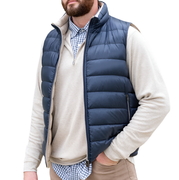 A man stands against a white background, wearing the Herno Nylon Reversible Vest over a light sweater and checkered shirt.