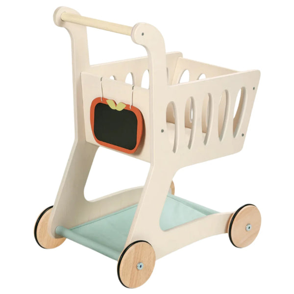 The Tender Leaf Shopping Cart by Tender Leaf Toys is a charming wooden cart that boasts an apple-shaped chalkboard cutout on the front and a fabric base. It glides effortlessly on four wheels and includes a convenient lower shelf for storage.