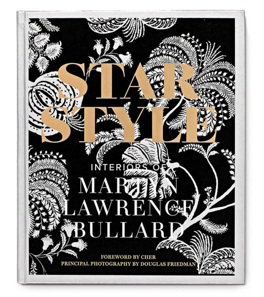 Cover of the book "Star Style: Interiors of Martyn Lawrence Bullard" by Vendome, featuring a black and white ornate floral pattern background with gold lettering. Foreword by Cher, photography by Douglas Friedman. Dive into the world of eclectic interiors and celebrity homes crafted by Bullard himself.