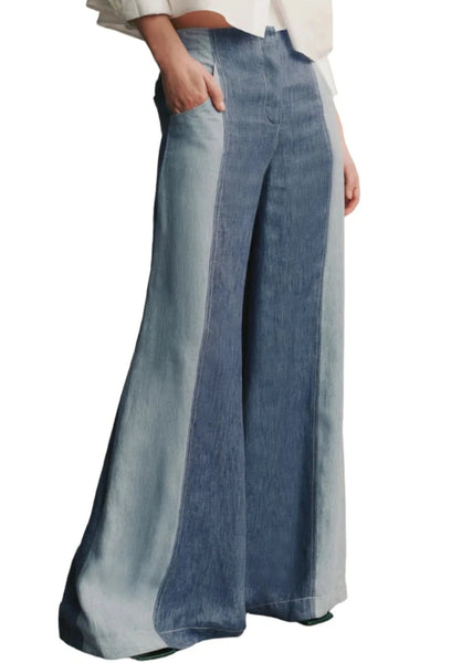 Person wearing TWP's TWP Demi Hemp Denim Pant with one hand in the pocket, and a light-colored top partially visible. The pants have a dramatic wide leg and a light stripe along the inner and outer seams.