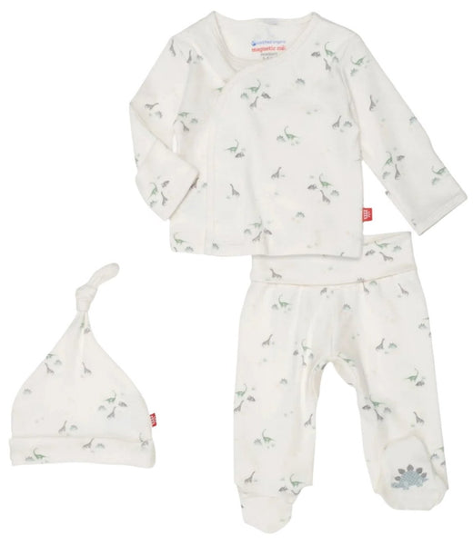 The Magnetic Me Tiny Diny Kimono Set features a white, long-sleeve shirt, pants, and a hat adorned with small dinosaur prints. Made from organic cotton and designed with SewSafe™ magnetic closures for easy changes, this newborn kimono set from Magnetic Me ensures comfort and safety for your little one.