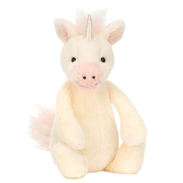 The Jellycat Bashful Unicorn, Small, featuring soft vanilla fur, a light pink nose, and a shiny holographic horn, sits upright against a plain white background.