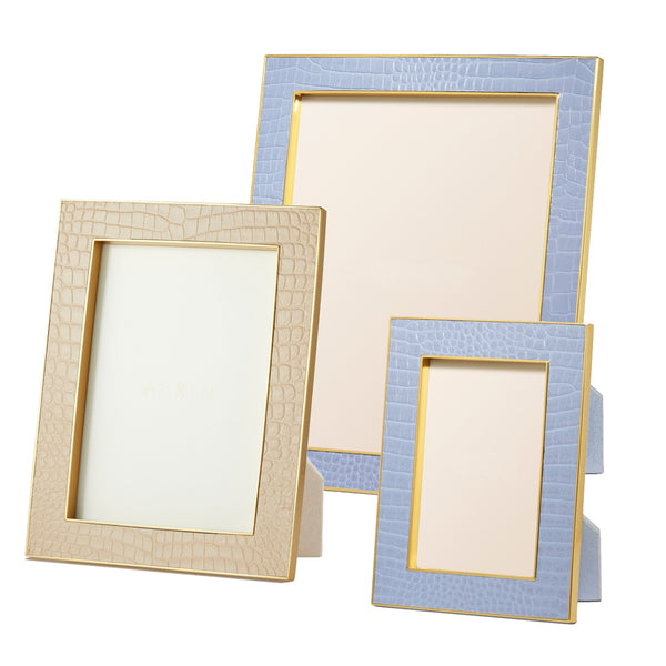 Three elegant frames from the AERIN Classic Croc Leather Frame Collection by Aerin, crafted in beige and light blue Italian croc-embossed leather with gold trim and suede lining, showcased standing on a white background.