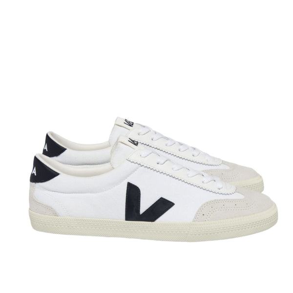 The VEJA Volley Sneaker by Veja is a pair of white low-top sneakers featuring black "V" logos on the sides and black accents at the heels, made from organic cotton and Amazonian rubber.