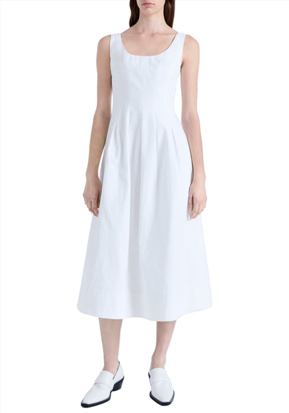 A person is standing wearing a sleeveless, white, mid-length Proenza Schouler Shelby Dress with a fit and flare silhouette and white slip-on shoes, against a plain white background.