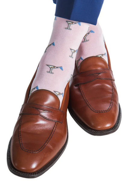 A person wearing brown leather loafers, Dapper Classics 19th Hole Martini Glass Mid Calf Socks in pink and azure blue, paired with blue pants.