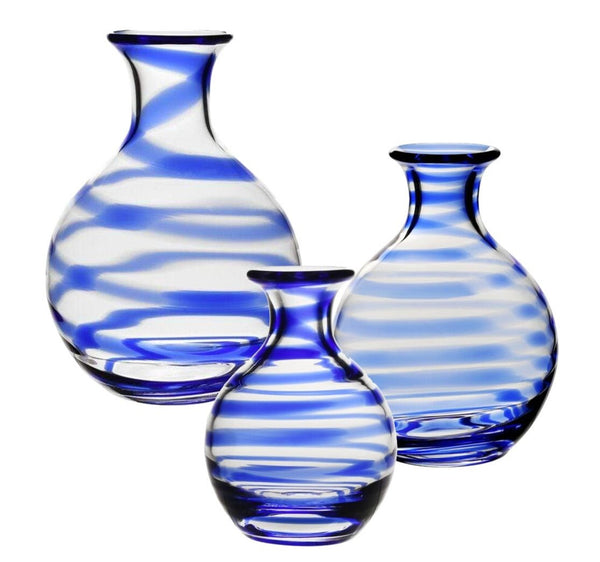 Three pieces from the William Yeoward Crystal Bella Blue Carafe Collection, featuring round glass designs with blue and white swirl patterns, are displayed against a white background, evoking the essence of summer skies.