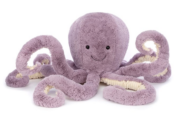 A Jellycat Maya Octopus, Really Big, with a smiling face and multiple jumbo corduroy tentacles is displayed against a plain, white background. The dusky mauve hue of its body adds an elegant touch.