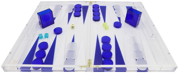 A vibrant Tizo Design Tizo Lucite Backgammon Set Collection featuring blue and white triangles, acrylic blue and white checkers, blue dice, and green dice. Two matching blue dice cups are placed near the board.