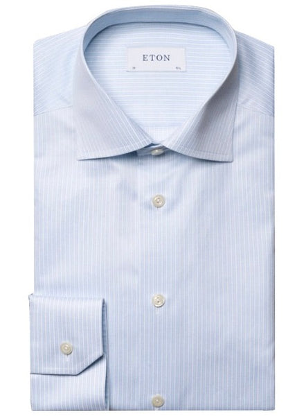 The folded Eton Light Blue Reverse Striped Signature Twill Shirt, Slim Fit features thin white stripes on a light blue backdrop and includes a label at the collar reading "Eton." This elegant piece is crafted from their signature twill fabric.