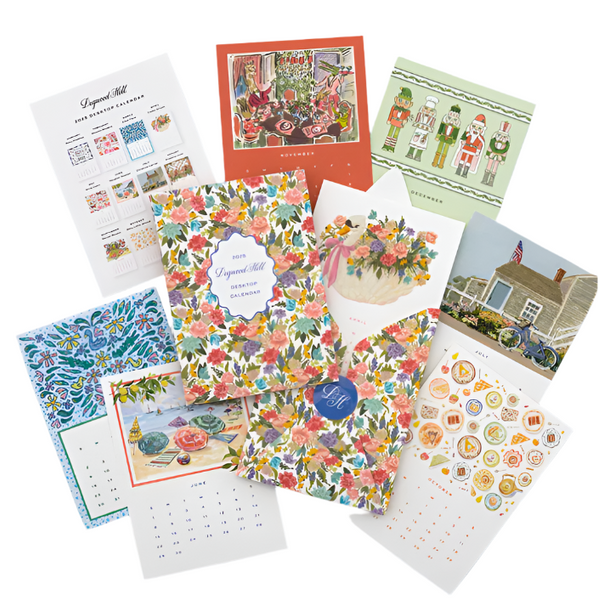 A variety of colorful calendar pages are spread out, each showcasing different original artwork including floral patterns, holiday themes, and illustrated scenes. A central booklet titled "Lynnette Shelley 2025 Calendar" is included. This Dogwood-Hill Desktop Calendar Refill offers stunning visuals for every month.